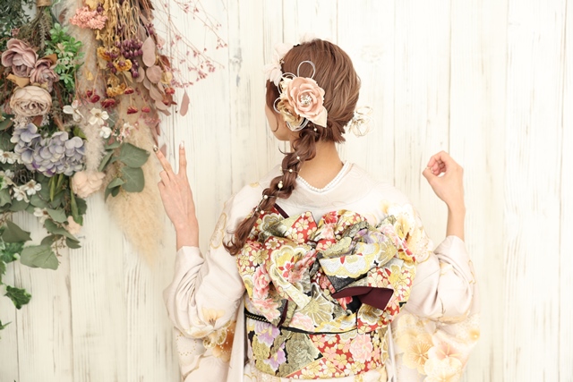 くすみピンクの振袖にあわせて、髪色もピンクに。編みおろしヘア×お花カチューシャで可愛らしい印象に