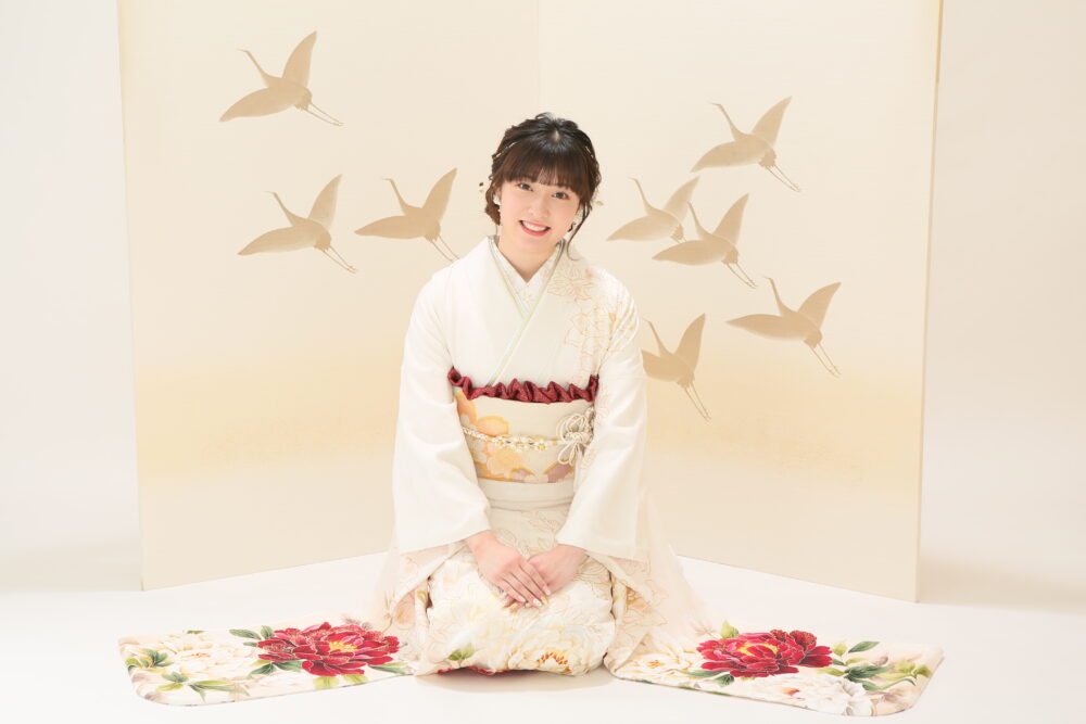 正座をする白い振袖を着た女性