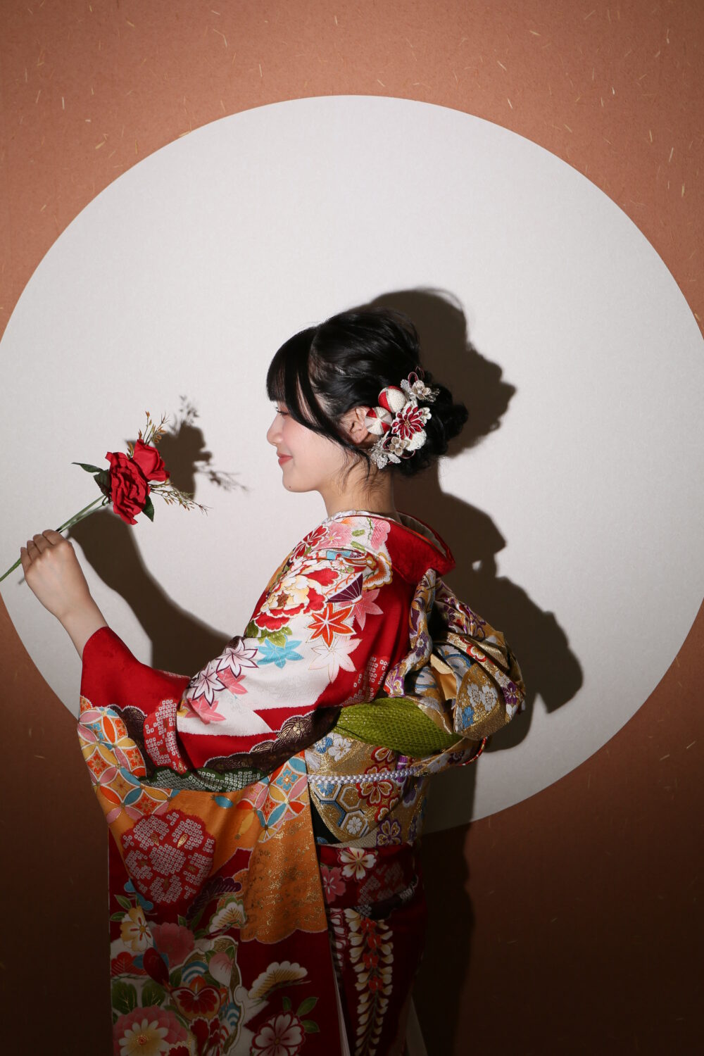 バラを見て微笑む女性