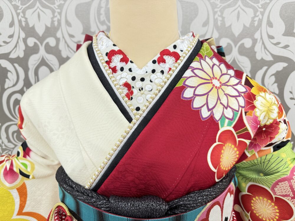 白と赤を基調とした振袖に、白地に黒いドット（水玉）柄が施されたとても珍しいデザインの半衿と、黒地にパールが連なる重ね衿を使用した振袖コーディネート