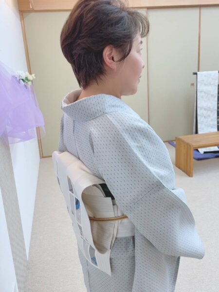 夏の単衣着物に一重太鼓を結んでいる女性