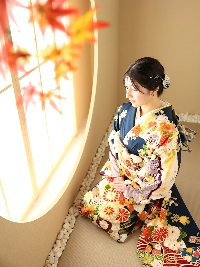 成人式前撮り撮影紺地の振袖を着て座る女性