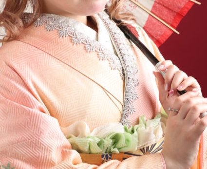 ピンク色のママ振りを着た女の子が傘を持っている