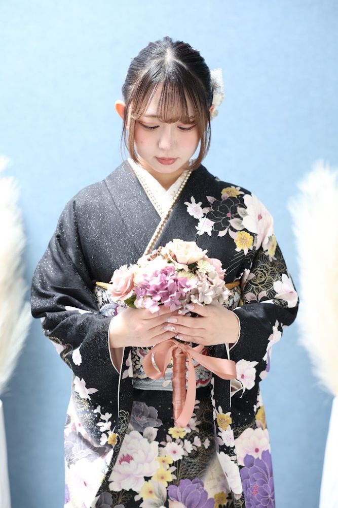 成人式前撮り 黒地の振袖を着てブーケをもつ上半身画像